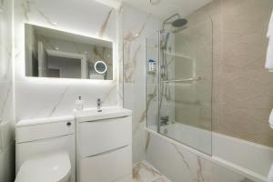 a white bathroom with a shower and a toilet at New in Willesden close to Oxford Str, Wembley, Jubilee line in London