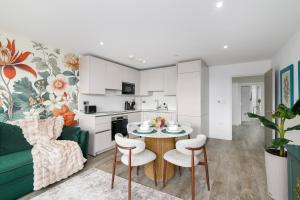 a living room with a green couch and a table and chairs at New in Willesden close to Oxford Str, Wembley, Jubilee line in London +16 photos