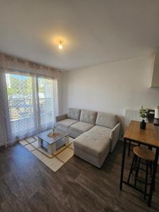 a living room with a couch and a table at Le Nid Urbain in Villiers-le-Bel