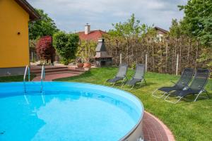 einen Pool in einem Garten mit zwei Stühlen in der Unterkunft Ferienhaus Sabine Balatonberény in Balatonberény