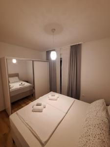 ein Schlafzimmer mit einem Bett, auf dem zwei Handtücher liegen in der Unterkunft Apartment24 in Široki Brijeg