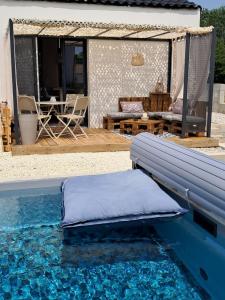 a pool with a bench next to a house at Appartement Soubise, le Bonheur Côté Mer in Soubise