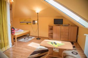 ein Dachzimmer mit Tisch und Fernseher in der Unterkunft Ferienhaus Sabine Balatonberény in Balatonberény