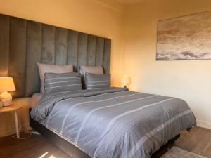 a bedroom with a large bed with three pillows at Skimbo's Apartment in Lusaka