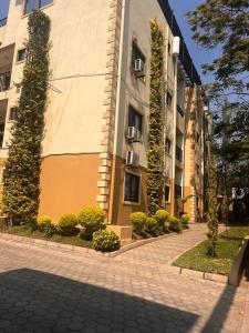 a building with trees and bushes in front of it at Skimbo's Apartment in Lusaka