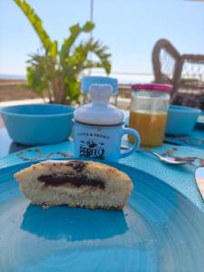 a piece of bread on a blue plate with a bottle of peanut butter at Paradise Sea Terrace in Monopoli