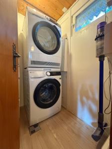 Waschmaschine und Trockner in einem winzigen Haus in der Unterkunft Chalet Opalpin Lodge & Spa, vue montagne et jacuzzi in Saclentse