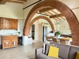 an open kitchen and living room with a brick archway at La Capanna 1857 in Peccioli