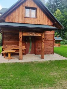 a large wooden building with a bench in front of it at Chatka Podzawale in Bircza