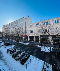 a snow covered street in front of a building at Gdynia Abrahama 23 in Gdynia