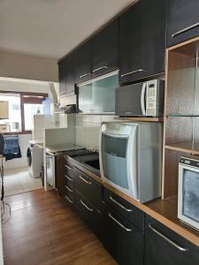 a kitchen with stainless steel cabinets and appliances at Ed Plaza Viena Apto 3 Quartos Vista Mar in Florianópolis