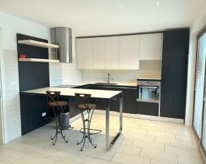 a kitchen with a table and two stools in it at Ciconi Apartment in Gorizia