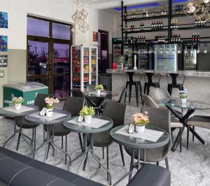 a restaurant with tables and chairs and a bar at Perriman Hotel in Kokrobite