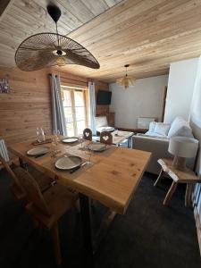 a wooden table in a living room with a couch at Maison Cœur Clarée in Névache