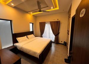 a bedroom with a bed and a ceiling fan at Couple Friendly Guest House in Karachi