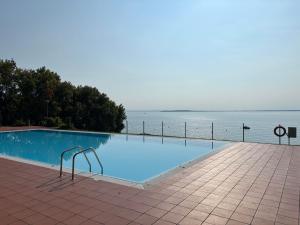 a swimming pool with a view of the water at Gardazzuro Appartment Deluxe in Padenghe sul Garda