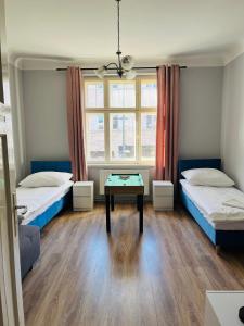 a room with two beds and a table in it at Gdynia Abrahama 23 in Gdynia