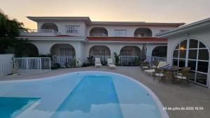 a swimming pool in front of a house at Santé Vivre L'expericénce, Búzios in Búzios