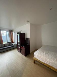 a bedroom with a bed and a dresser and a tv at Central Apartment in Nadi