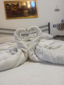 a pair of glasses sitting on a bed with towels at Casa di Roberta in Passoscuro