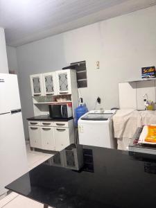 a kitchen with a stove and a refrigerator at Kitnet COP30 in Ananindeua