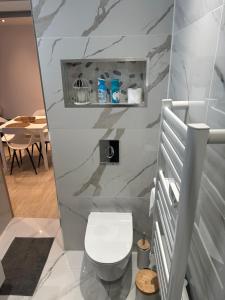 a bathroom with a white toilet in a room at Les 3 anges in Houilles +14 photos