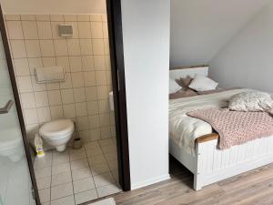 a small bathroom with a bed and a toilet at Deluxe Maisonette Ferienwohnung in Köditz +8 photos