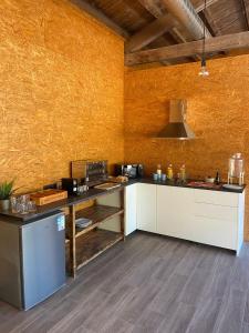 a large kitchen with white cabinets and a yellow wall at El Roble Glamping - Cabaña Container - Pet Friendly in Lagunilla
