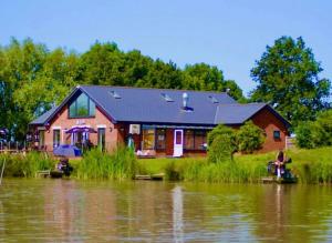 a house on the side of a body of water at Herons mead 12 in Addlethorpe