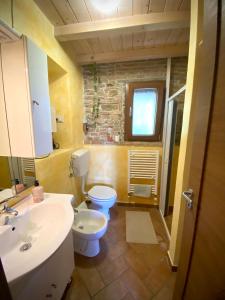 a bathroom with a sink and a toilet and a window at Villa Verde in Marconia