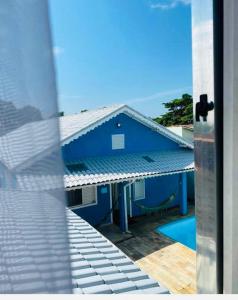 ein blaues Gebäude mit einem Pool davor in der Unterkunft Pousada Lume Beach House Peruíbe in Peruíbe