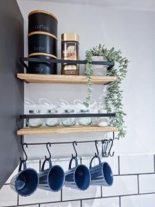 a kitchen shelf with pots and pans on it at Modern Central Flat with Garden & Parking in Southampton