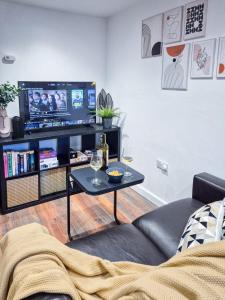 a living room with a couch and a table with wine glasses at Modern Central Flat with Garden & Parking in Southampton