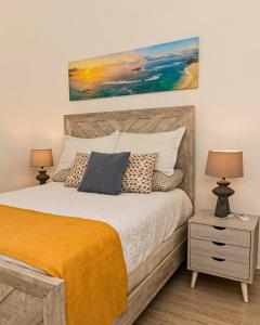 プンタ・カナにあるMaple Beach Residences Punta Canaのベッドルーム1室(ランプ2つ、絵画付)