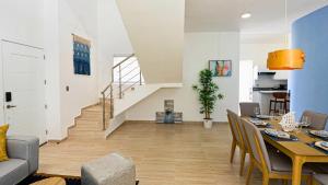 a living room with a dining table and a staircase at Maple Beach Residences Punta Cana in Punta Cana