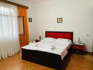 a bedroom with a large bed with two towels on it at Villa Gimi in Gjirokastër