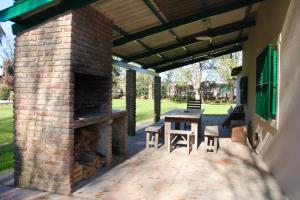 a patio with a brick fireplace and a table and chairs at La Quinta de Areco in San Antonio de Areco