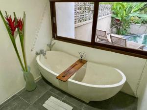 ウブドにあるEco Tini Villas Rice Fields and Jungle Viewの窓のある浴室の浴槽