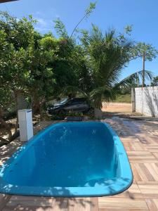 una piscina azul en un patio con árboles en Casa em carapibus com 2 andares e piscina, en Conde