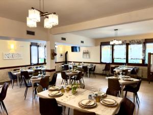 a dining room with tables and chairs and windows at Camping Bungalows Rio Jerte in Navaconcejo