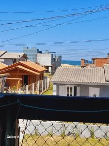 una vista di alcune case da una recinzione di kitnet Conjugado em Tramandai a Tramandaí