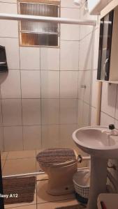 un bagno con doccia, WC e lavandino di kitnet Conjugado em Tramandai a Tramandaí
