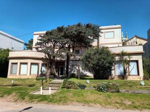 a large house with a tree in front of it at Ayres de Pinamar in Pinamar