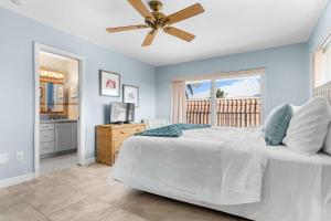 Sunset Harbor Waterfront Villa with Dock Cabana Club في Key Colony Beach: غرفة نوم بها سرير ومروحة سقف