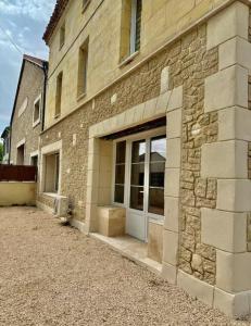 Un edificio de ladrillo con una puerta en el costado. en Charmant appartement à la campagne, en Arles