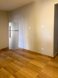 un frigorifero in una stanza vuota con un pavimento in legno di Apartamento em São Brás COP 30 a Belém