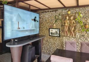 チェンマイにあるChiang Ronの壁のある部屋にある大画面テレビ