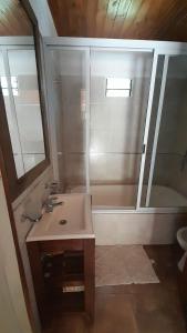 Un baño con ducha, lavabo y bañera. en La casita del bosque, en Valeria del Mar