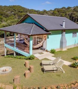 una casa con terraza y sillas en el patio en Pedra Azul - Casa Goiabeira II, en Domingos Martins