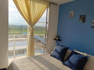 a bedroom with a bed and a large window at APARTAHOTEL para grupos a 4 min del Parque del Café in Estación El Salto